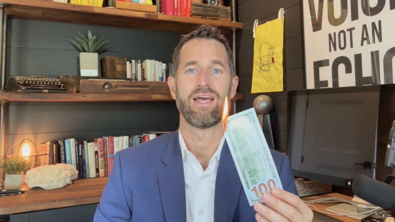 Bloomfield co-founder holding a burning hundred-dollar bill